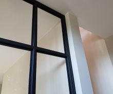 Strakke metalen deur met glas geplaatst door HNE Construct
