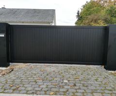 Moderne kwalitatieve metalen poort op de oprit van een huis