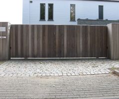 Houten moderne poort met stalen accenten op de oprit van een woning